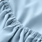 A close up of the elastic of a microfiber fitted sheet. 