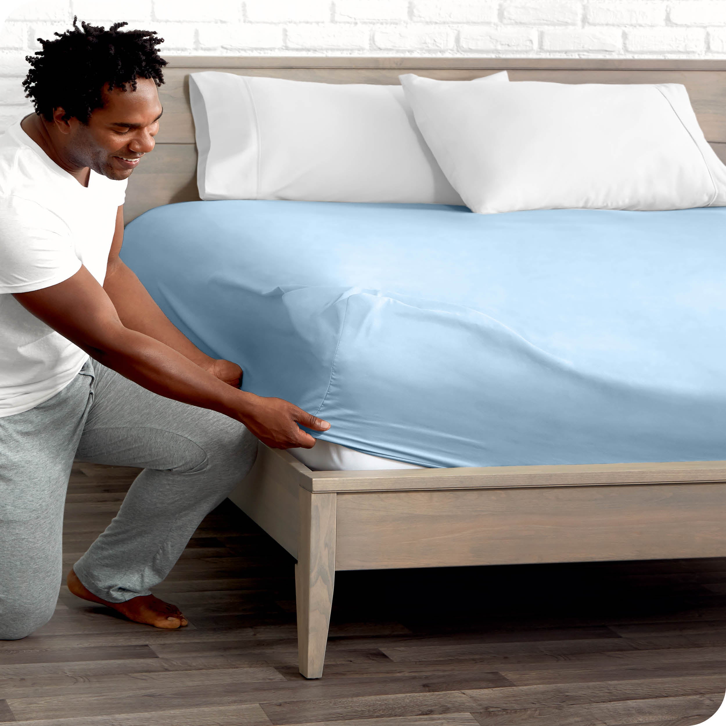 A man putting the microfiber fitted sheet on a mattress. 