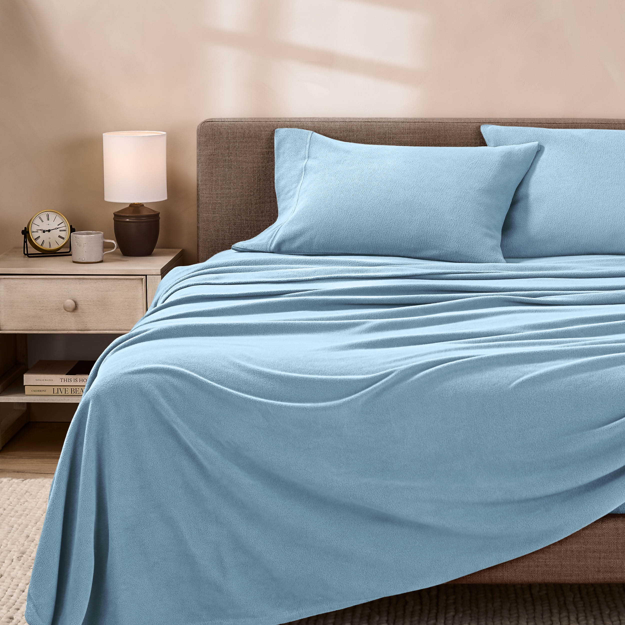 View of fleece sheets from the end of a bed with the top sheet draped over the side and end