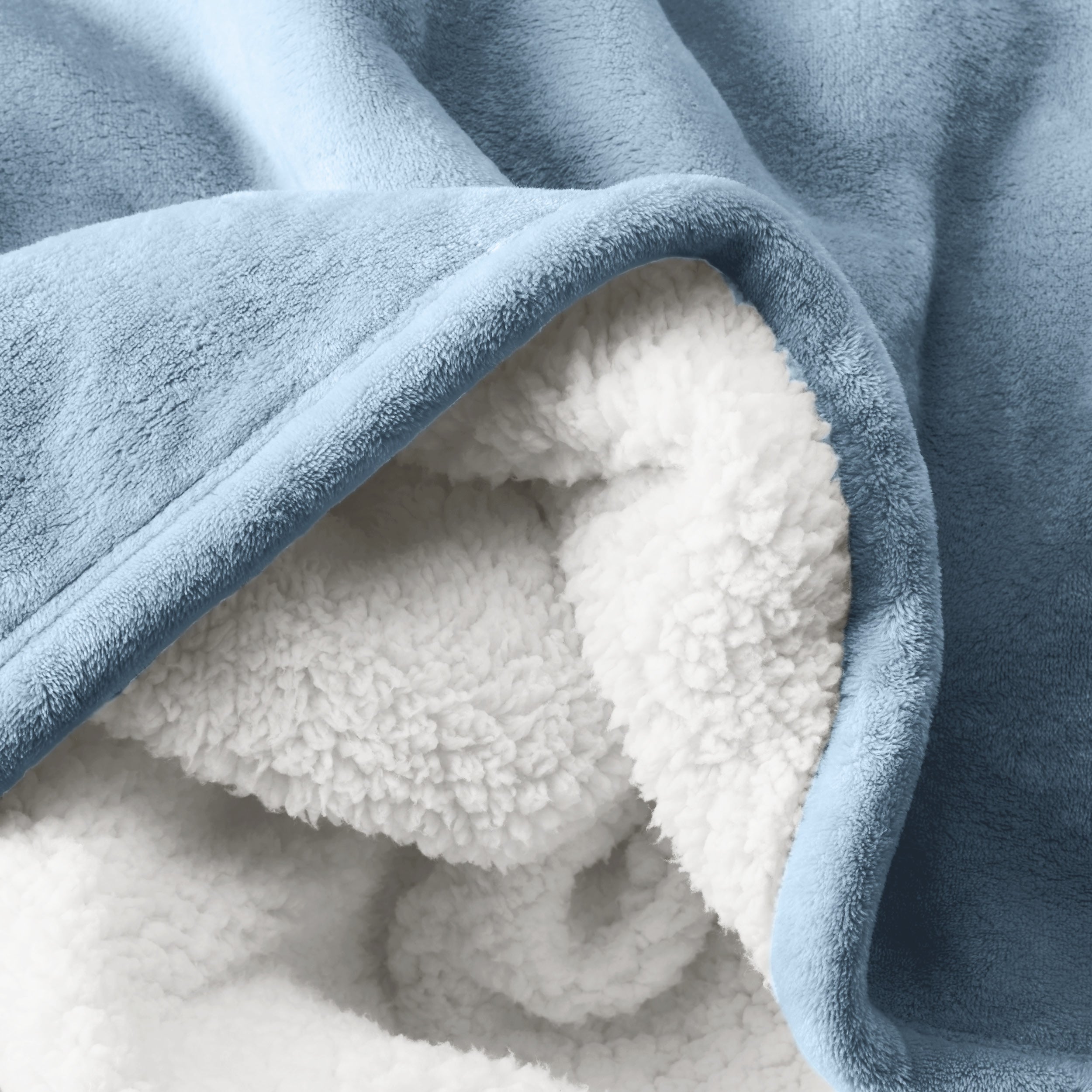 Close up of sherpa blanket showing texture of velvety soft side and sherpa backing