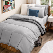 A college dorm room with a bed in a bag set on the mattress