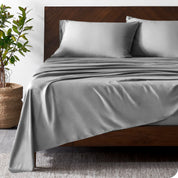 Wooden bed frame with bamboo sheets on the bed