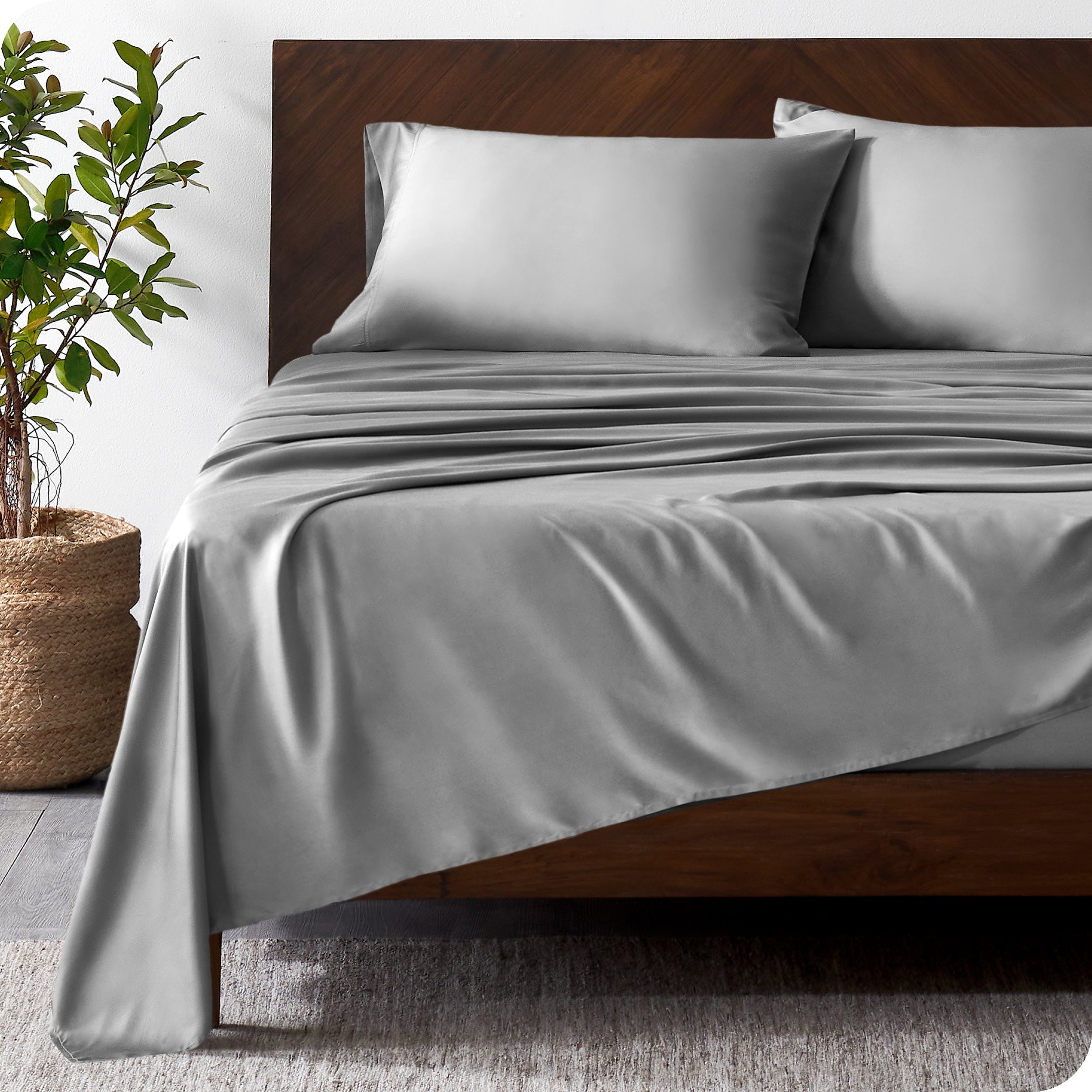Wooden bed frame with bamboo sheets on the bed