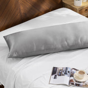 Bamboo body pillow on a bed with a magazine and cup of coffee nearby.