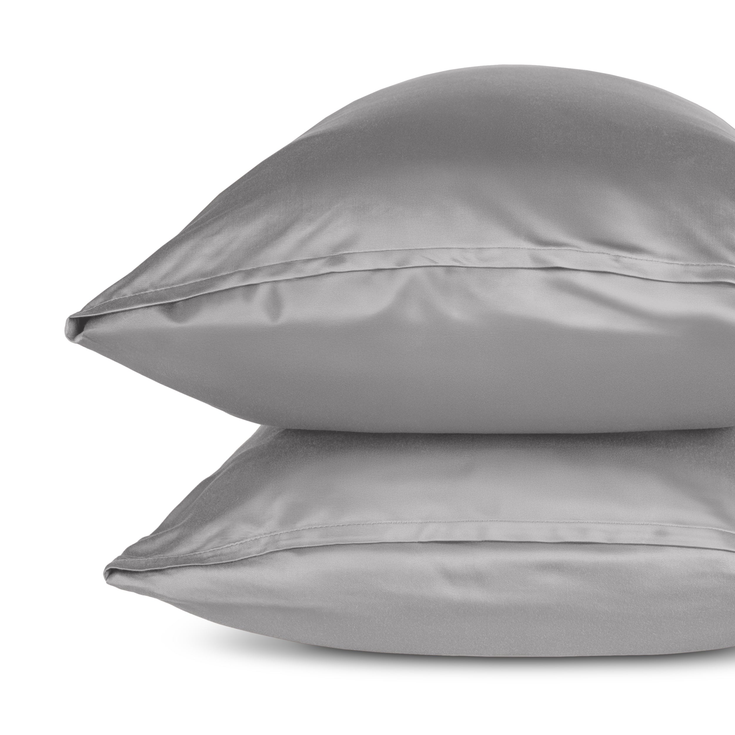Two pillows with pillowcases stacked on a white background