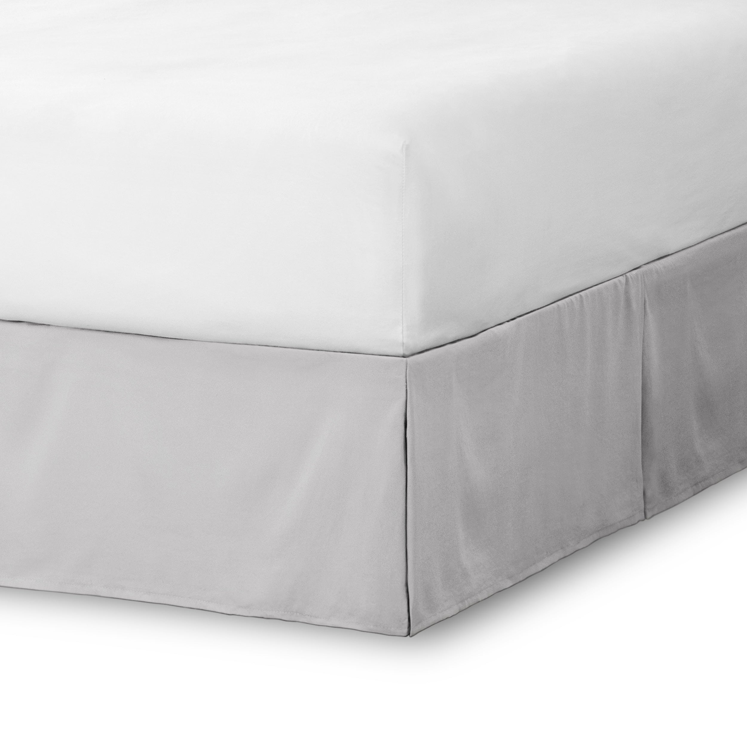 The corner of a bed skirt on a bed frame