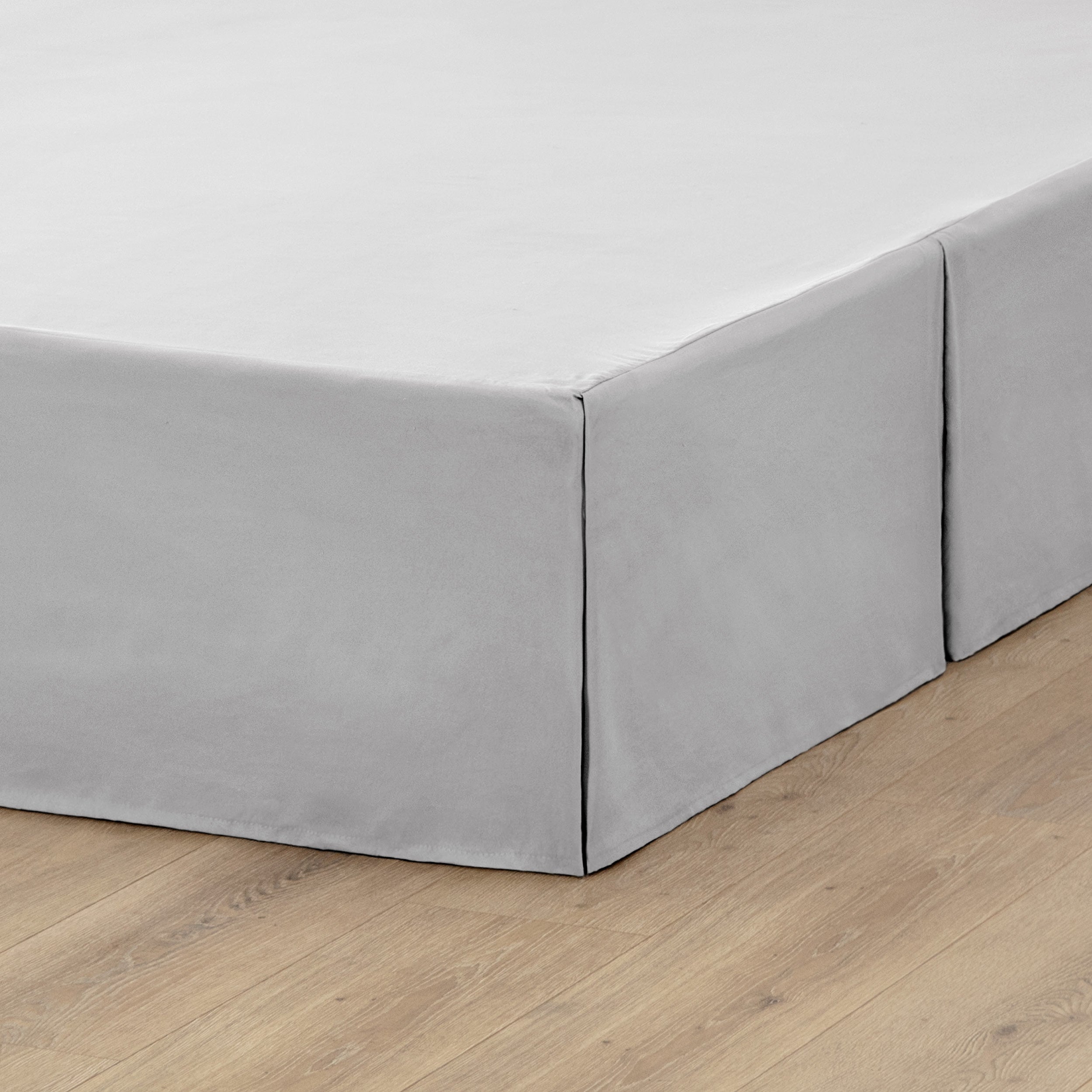 A box spring with a bed skirt on it