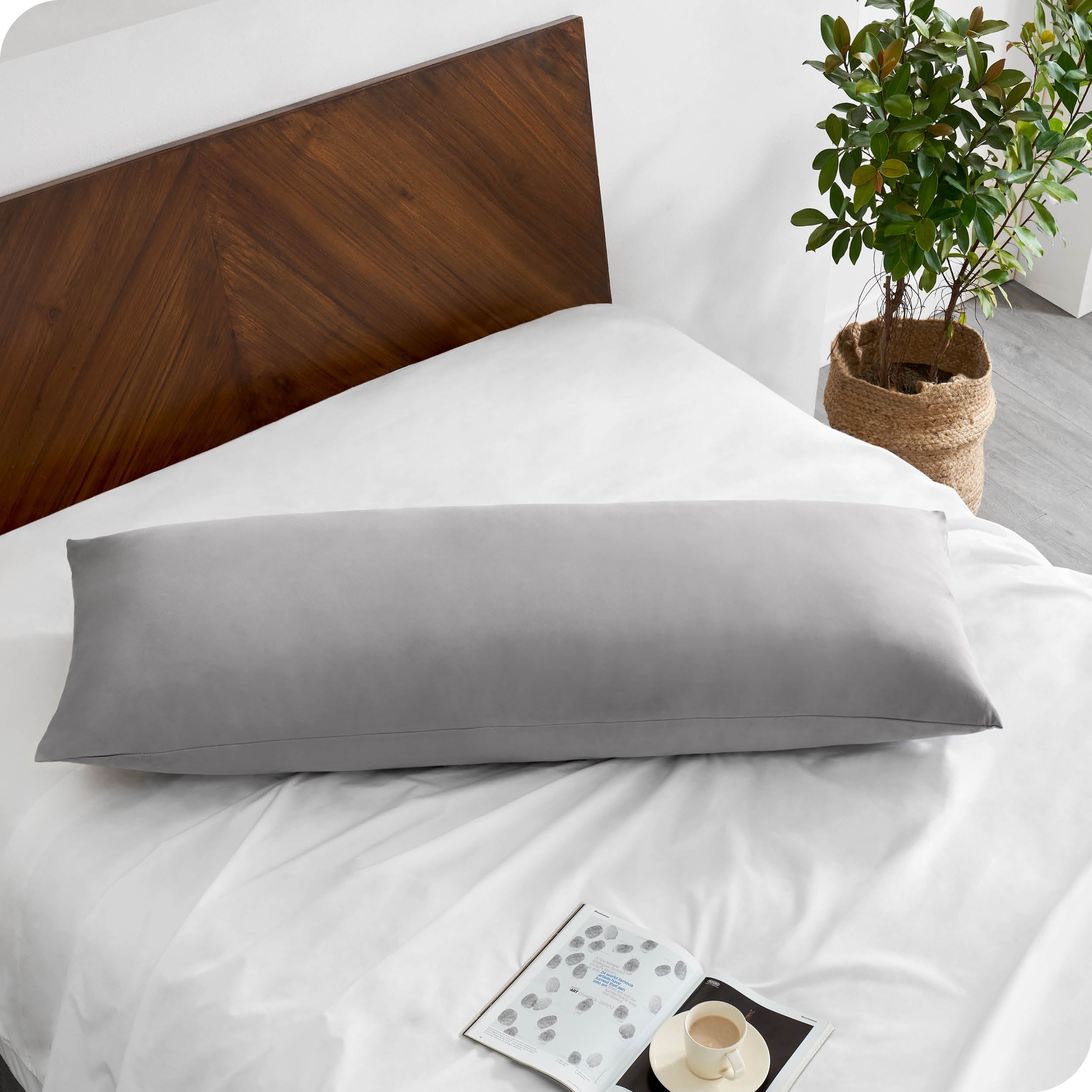 A body pillowcase on a pillow on a bed with all white bedding