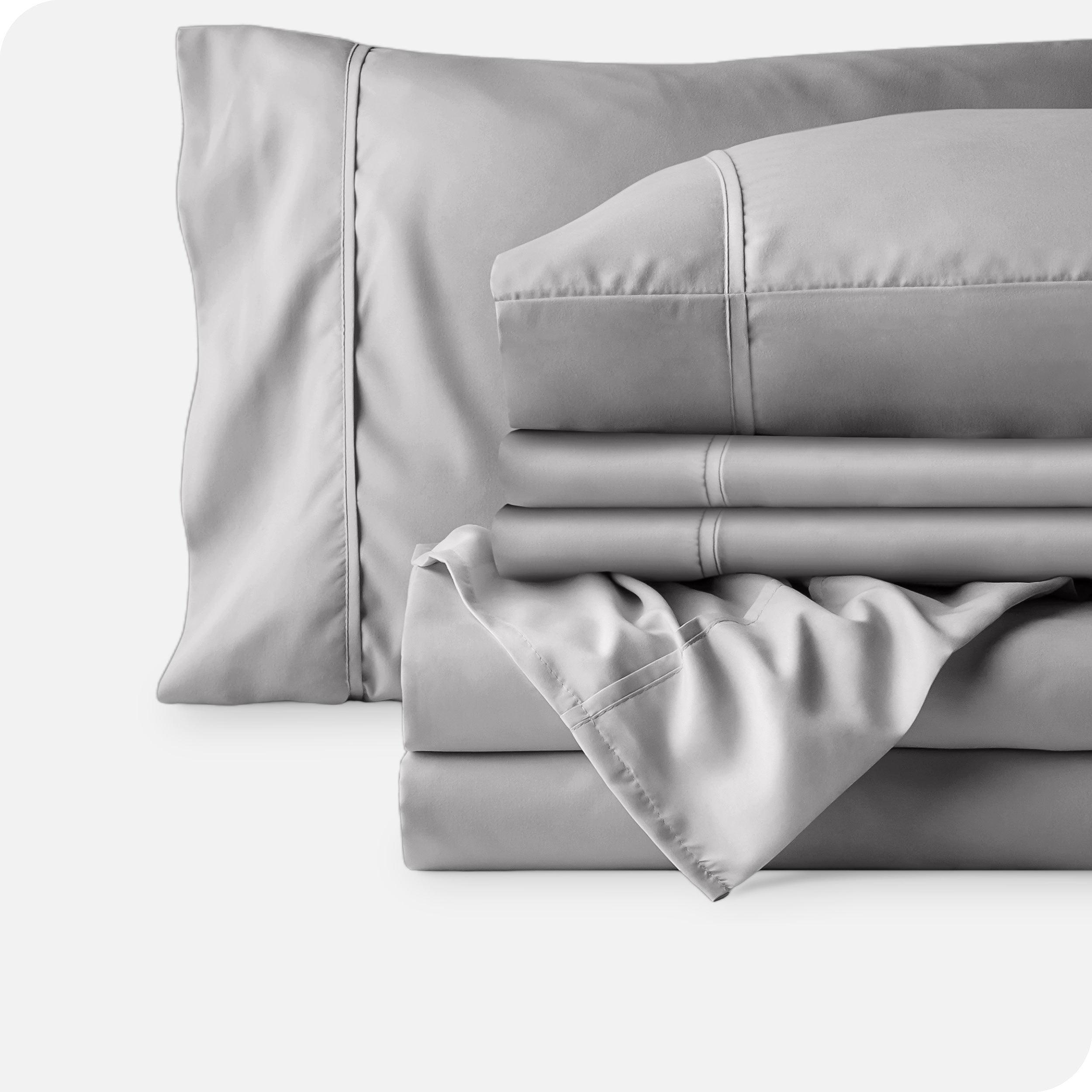Microfiber sheets neatly folded with corner draped over, two folded pillowcases and two display pillows.