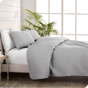 A coverlet set on a bed next to a window
