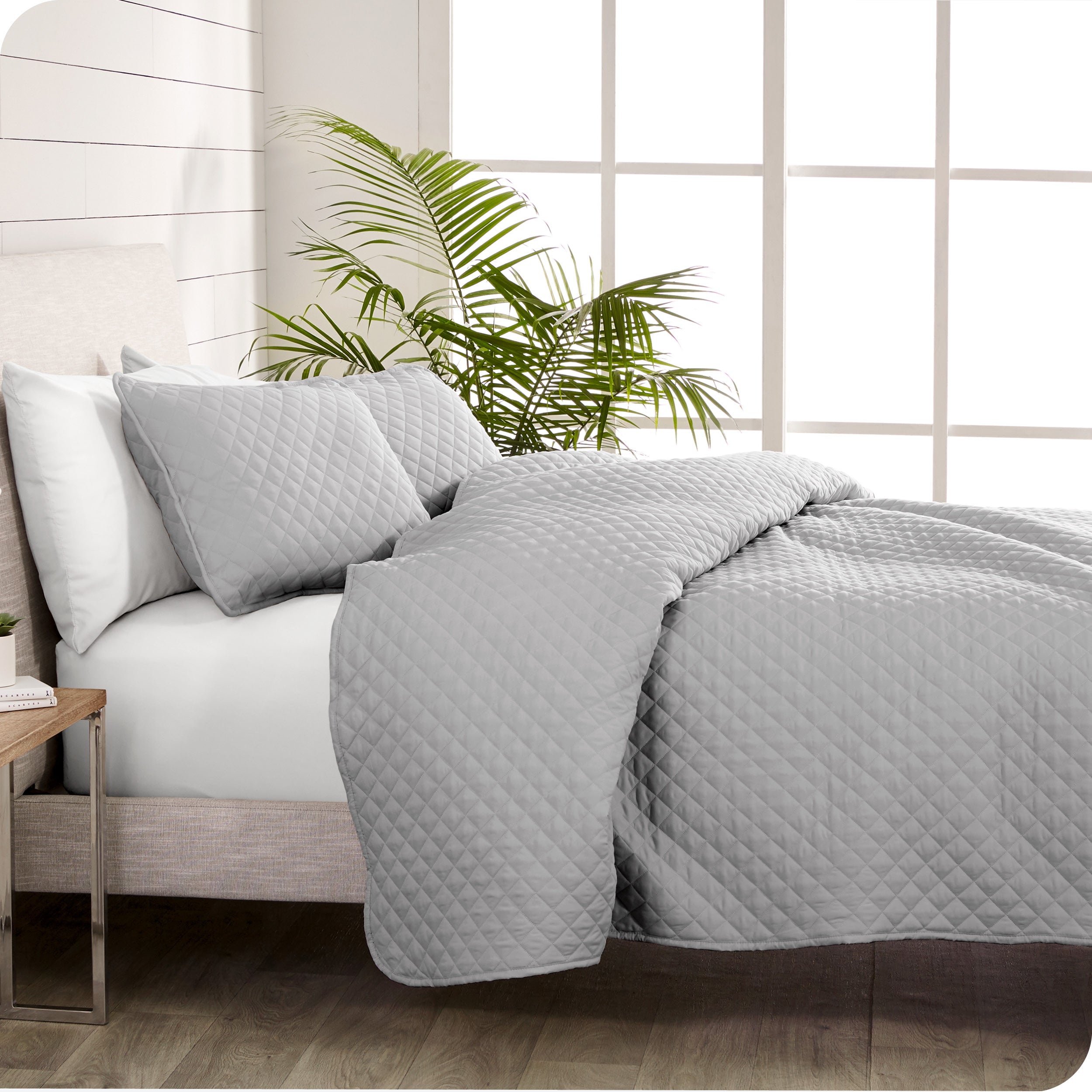 A coverlet set on a bed next to a window