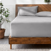 A modern bed with a fitted microfiber sheet made on the mattress. 