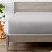 A modern bed with a fitted microfiber sheet on it