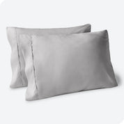 Two pillows on a white background with blue pillowcases on them