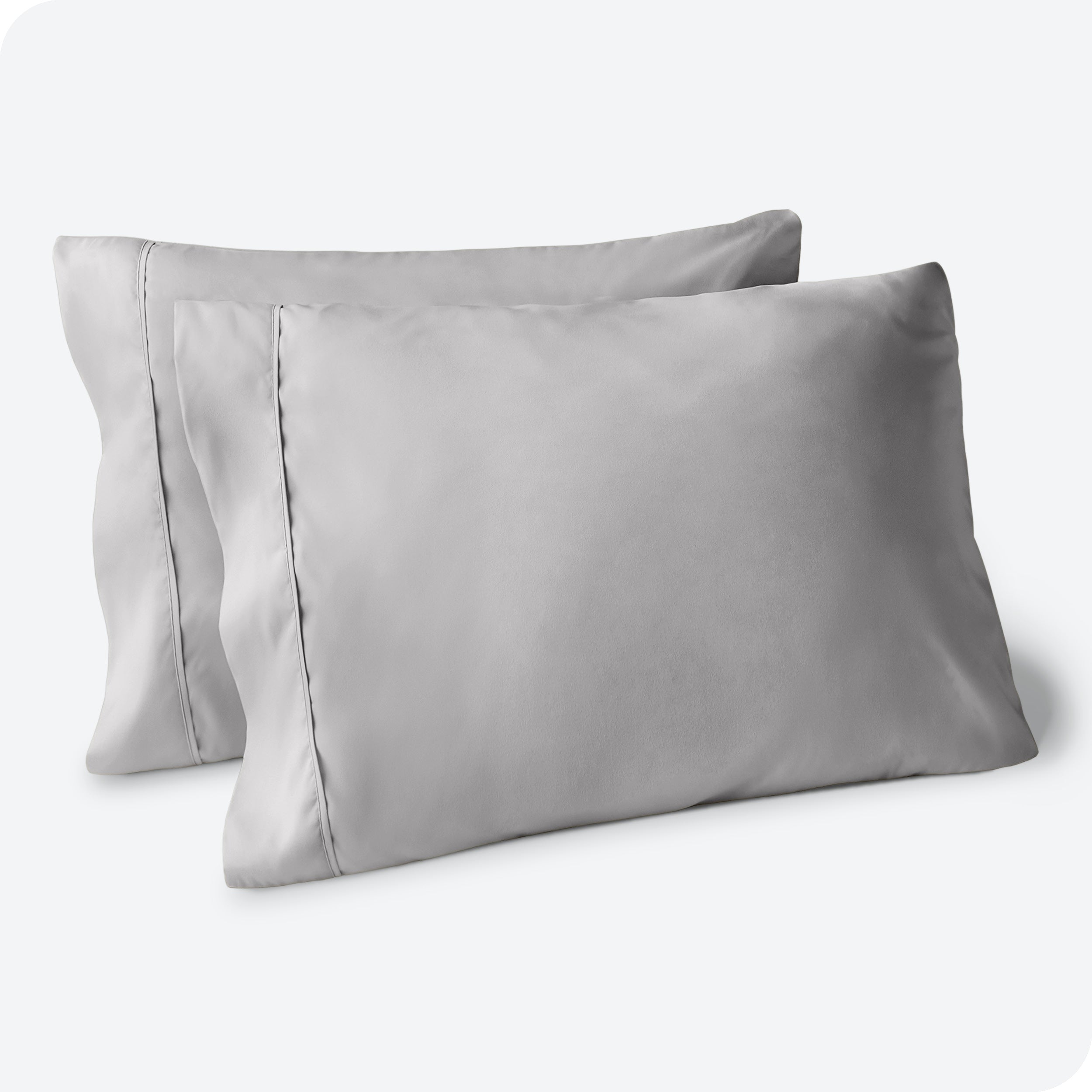 Two pillows on a white background with blue pillowcases on them