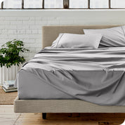 Microfiber sheets on a bed with a brick wall behind it