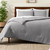 A comforter set on a bed with a dark wooden headboard