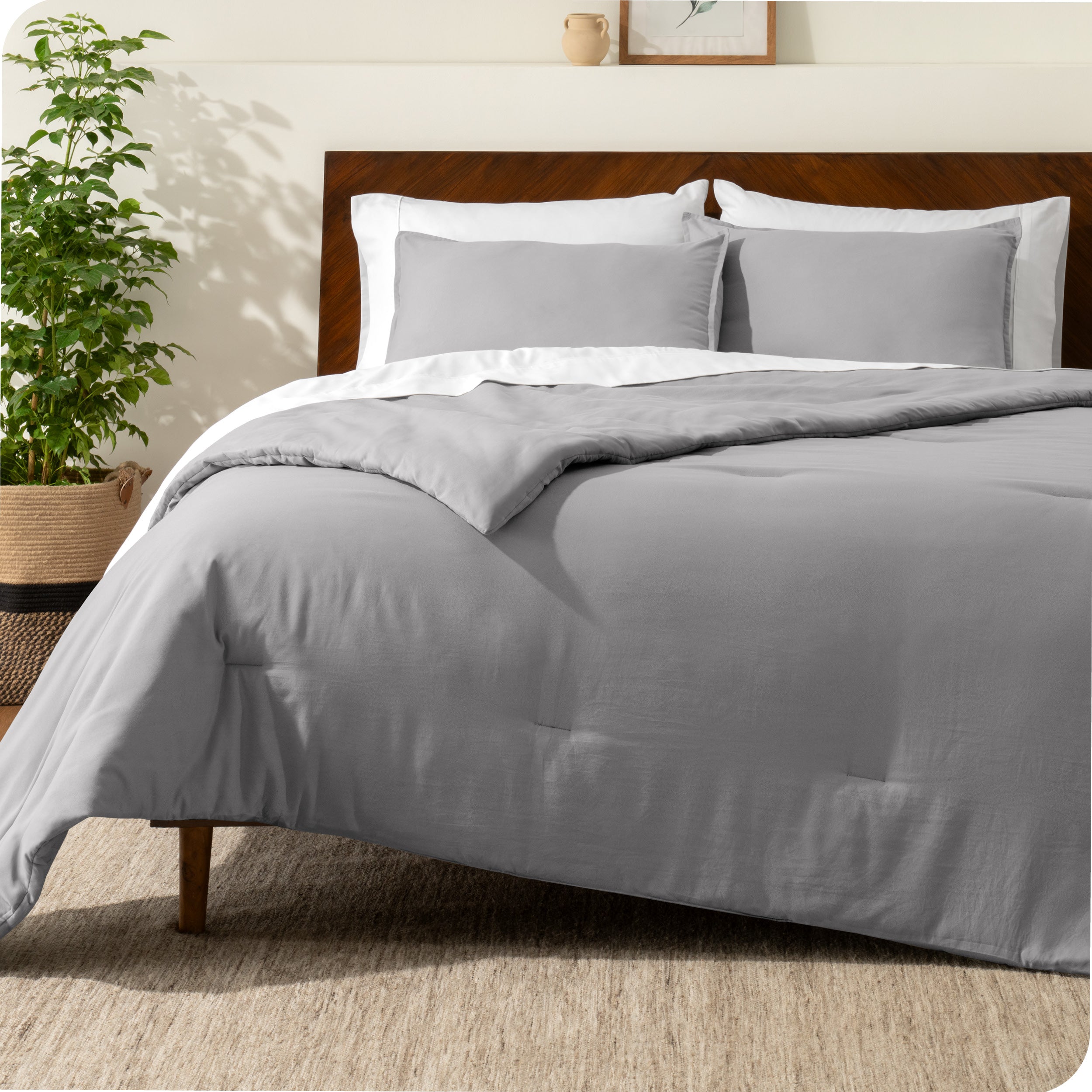 A comforter set on a bed with a dark wooden headboard