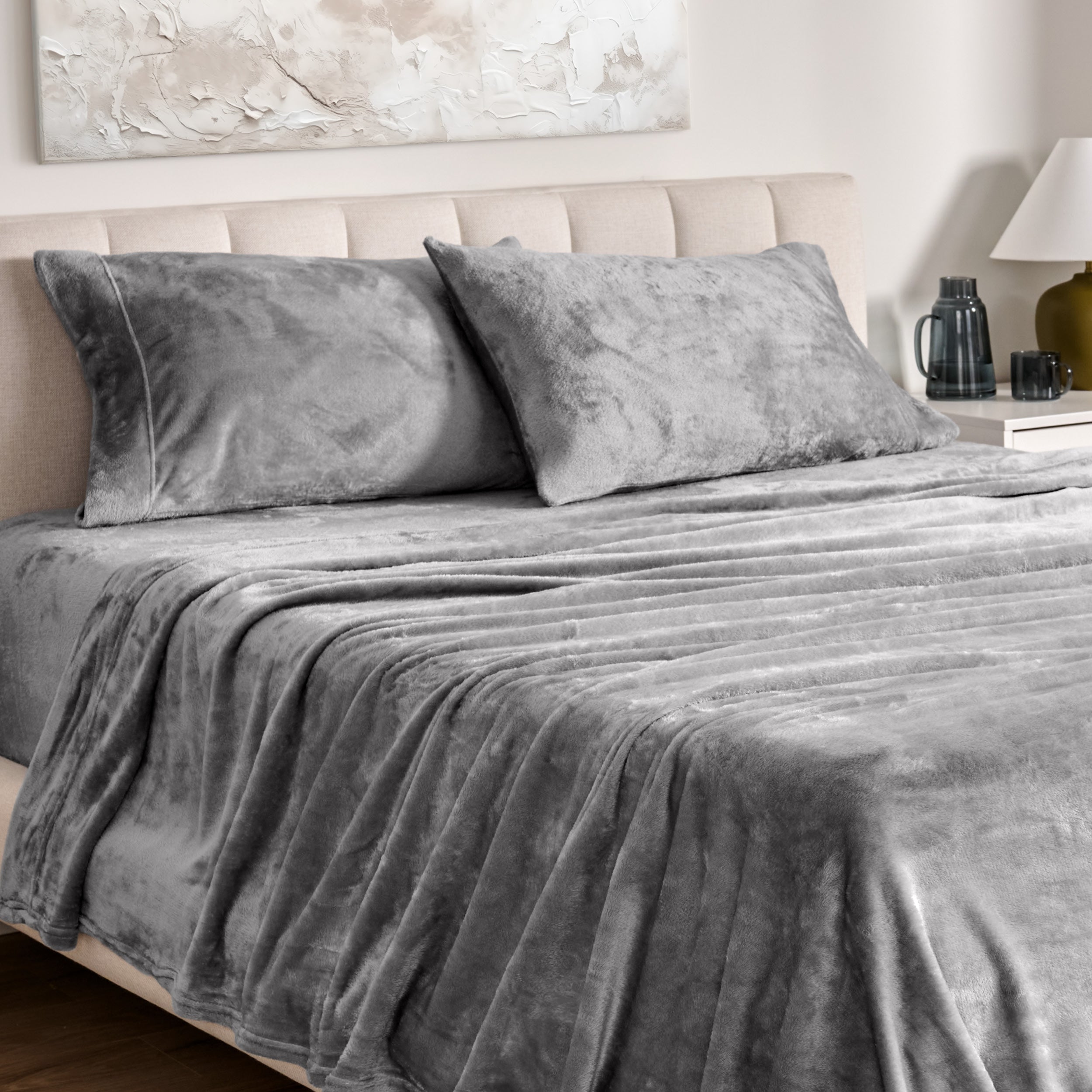 Microplush bed sheets and pillowcases on a bed with a neutral headboard and decor.