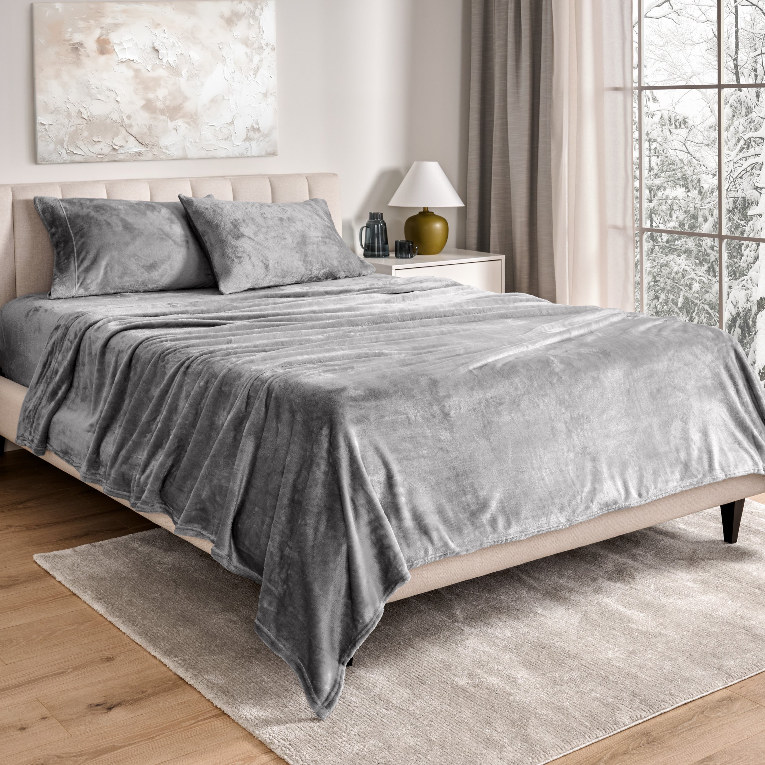 Sheets and matching pillowcases on a bed in a bedroom with a lamp and window in the background.