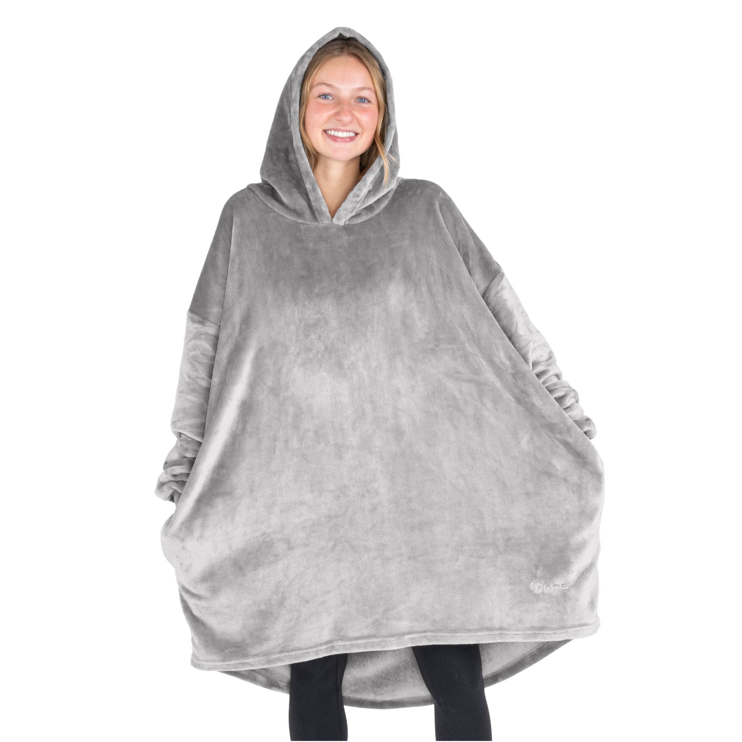 A woman standing with a wearable blanket on