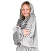 A woman is snuggled up in microplush wearable blanket