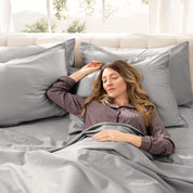 A woman sleeping on a bed made with organic cotton sateen sheets and pillowcases