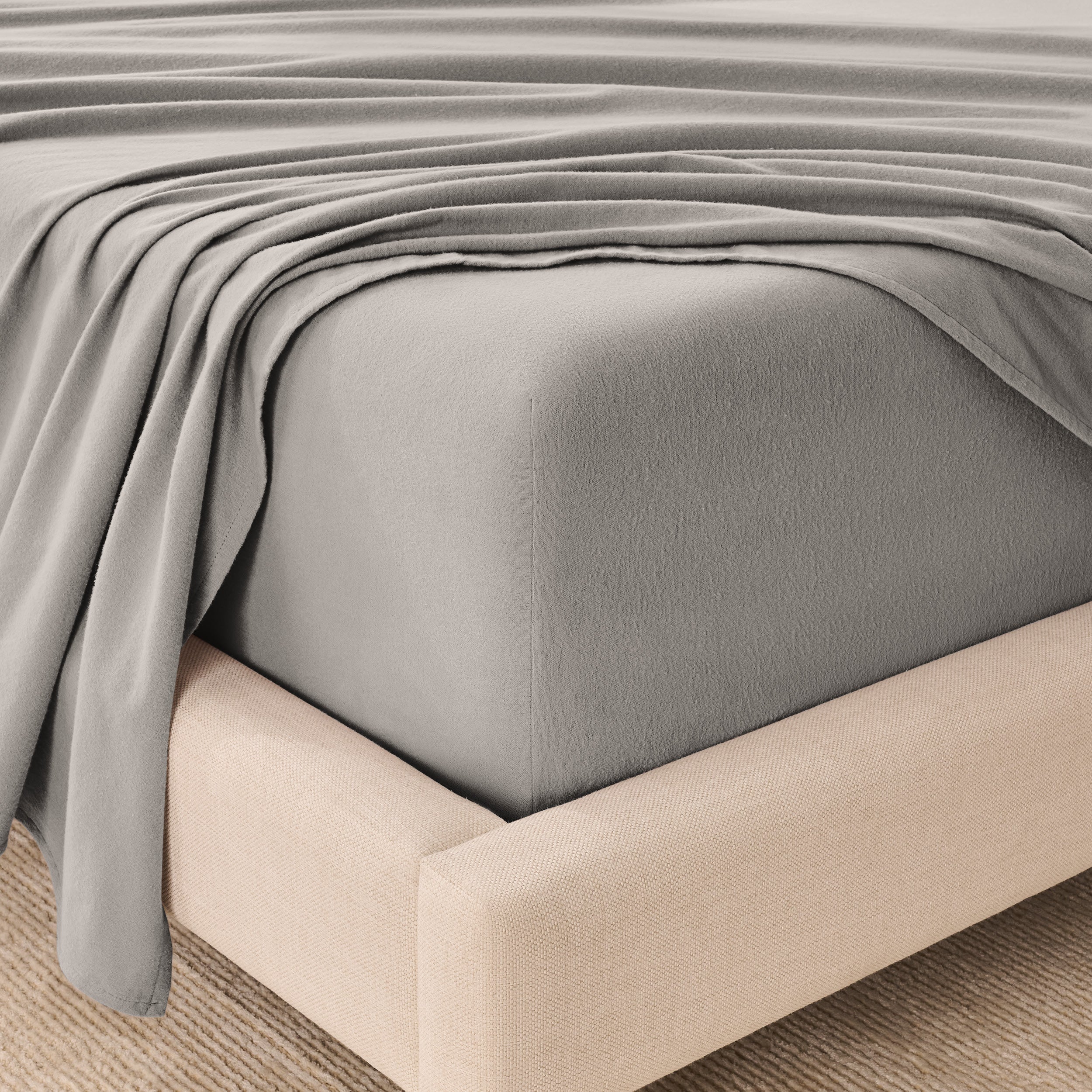 Organic flannel sheets on a beige bed frame