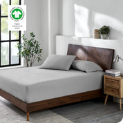 A bed made with a cotton jersey fitted sheet with 2 pillows near the headboard