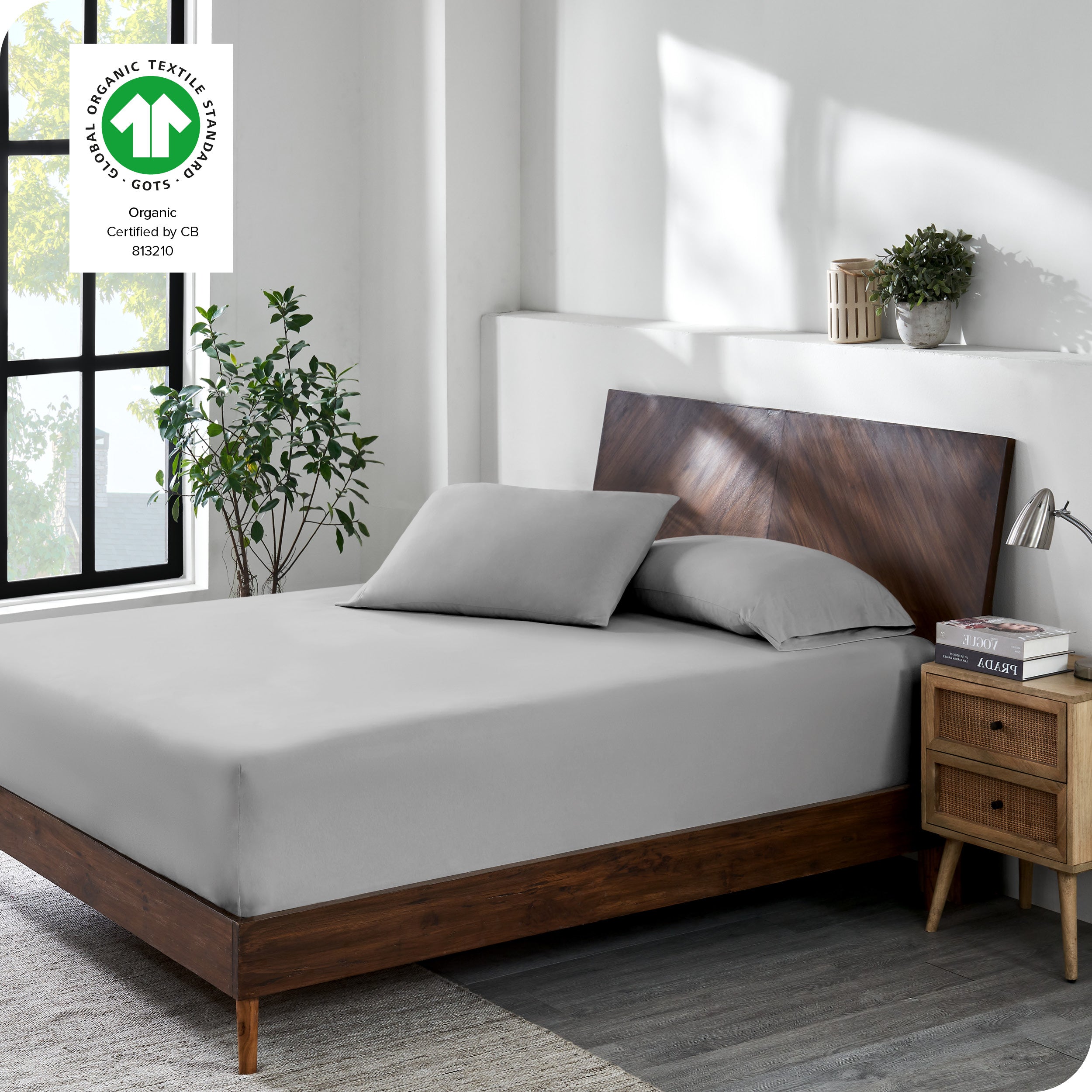 A bed made with a cotton jersey fitted sheet with 2 pillows near the headboard