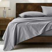 Percale sheet set on a bed with a wooden headboard