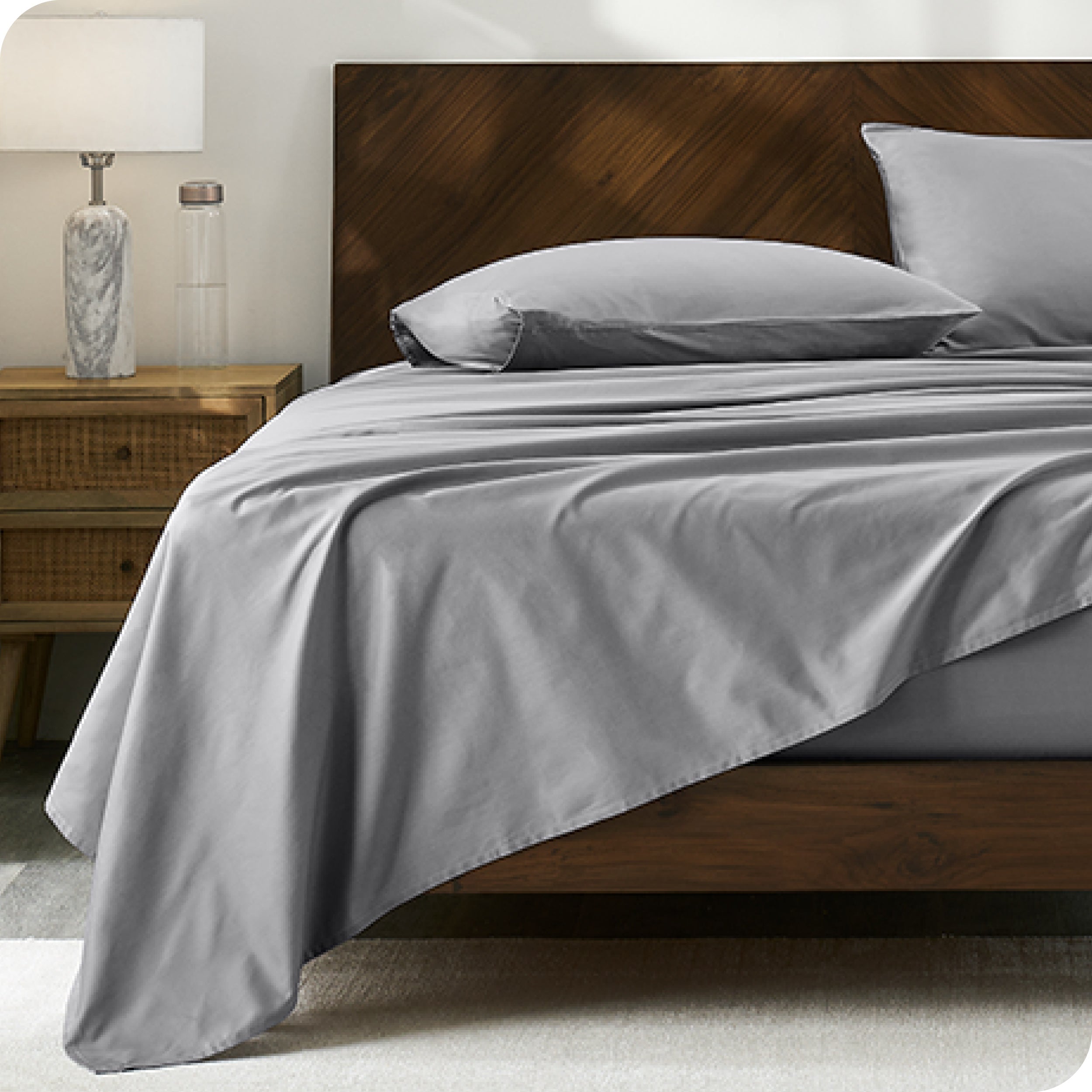 Percale sheet set on a bed with a wooden headboard