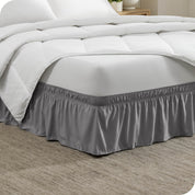 The corner of a bed with a polyester bed skirt on it