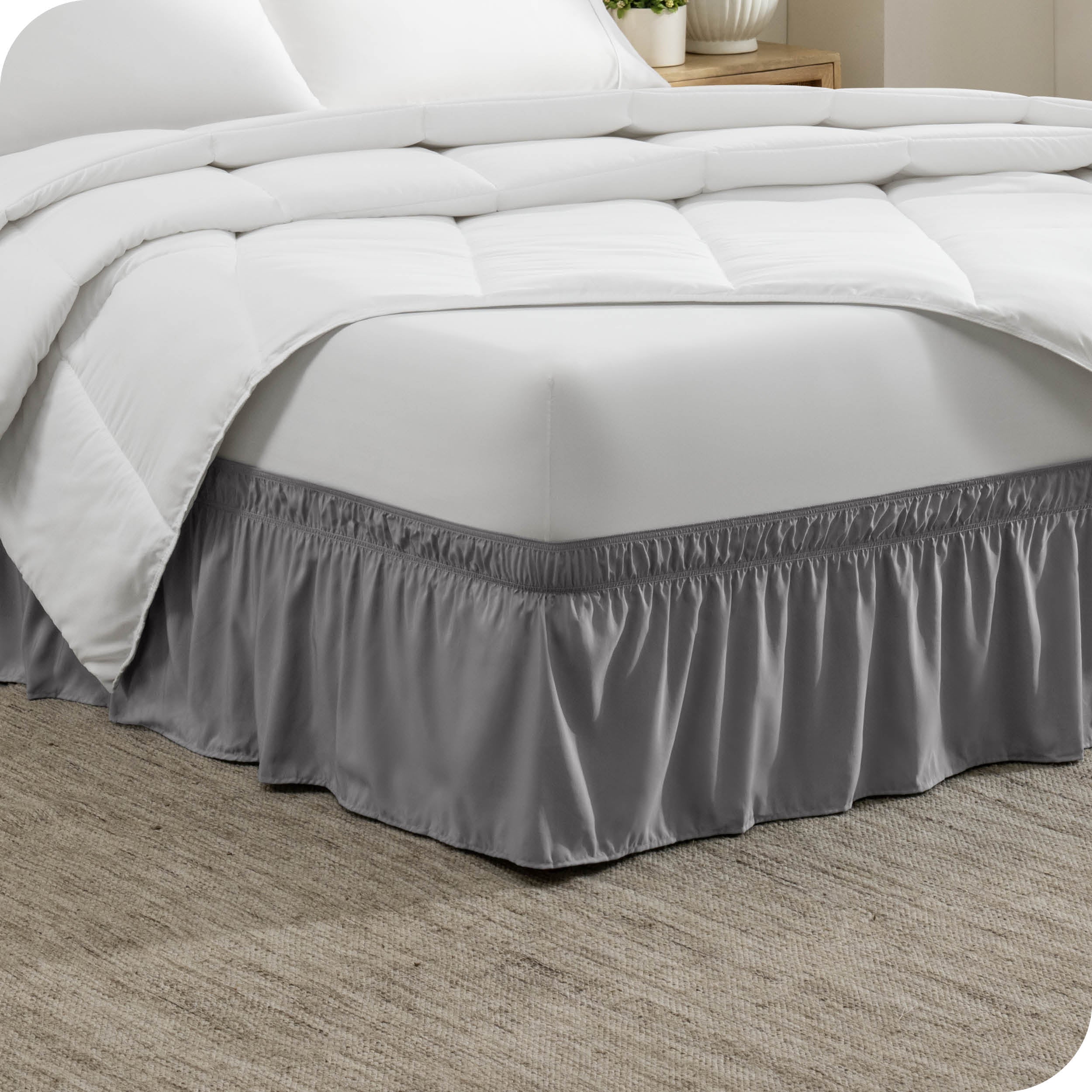 The corner of a bed with a polyester bed skirt on it