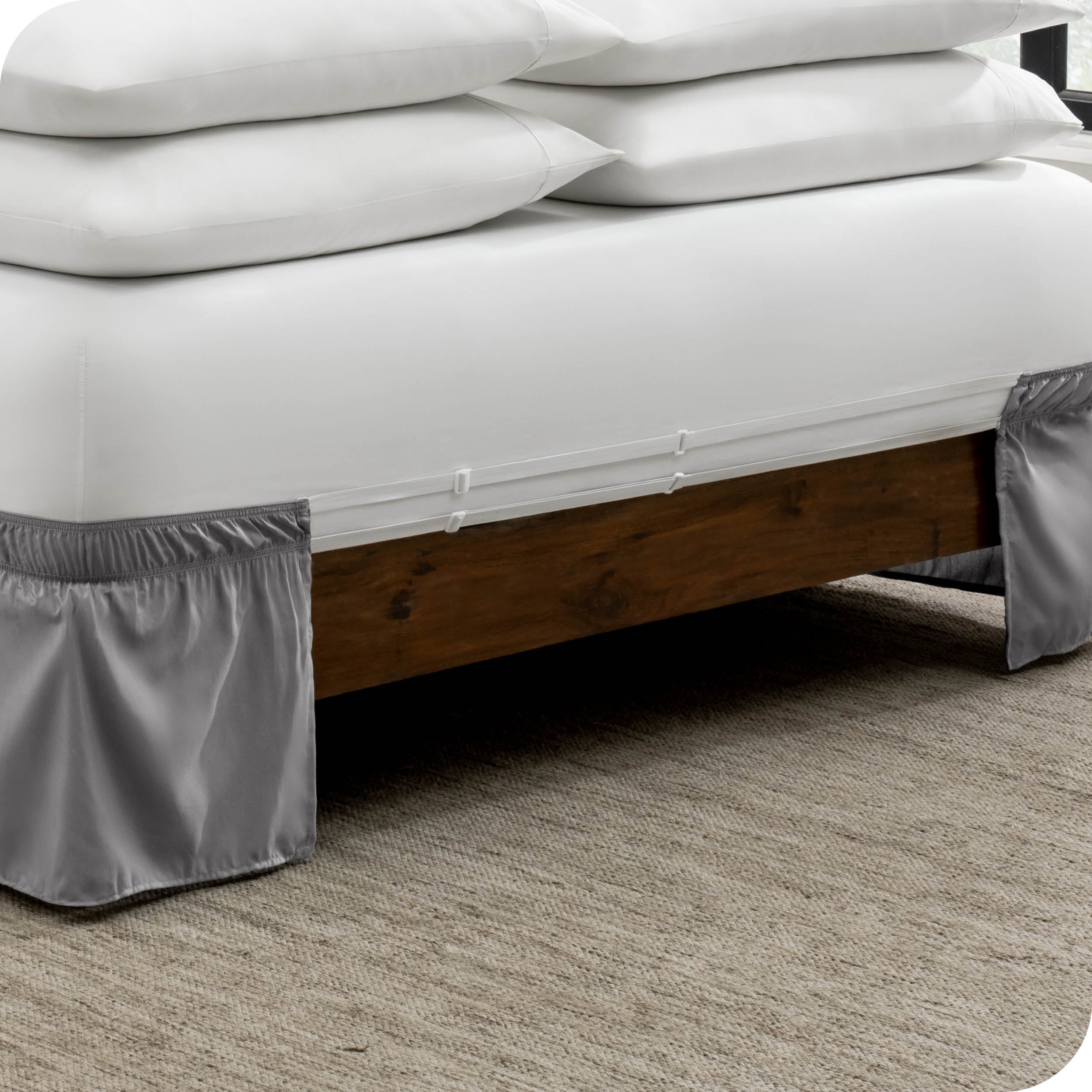 The adjustable elastic belt of a bed skirt wrapped around the mattress