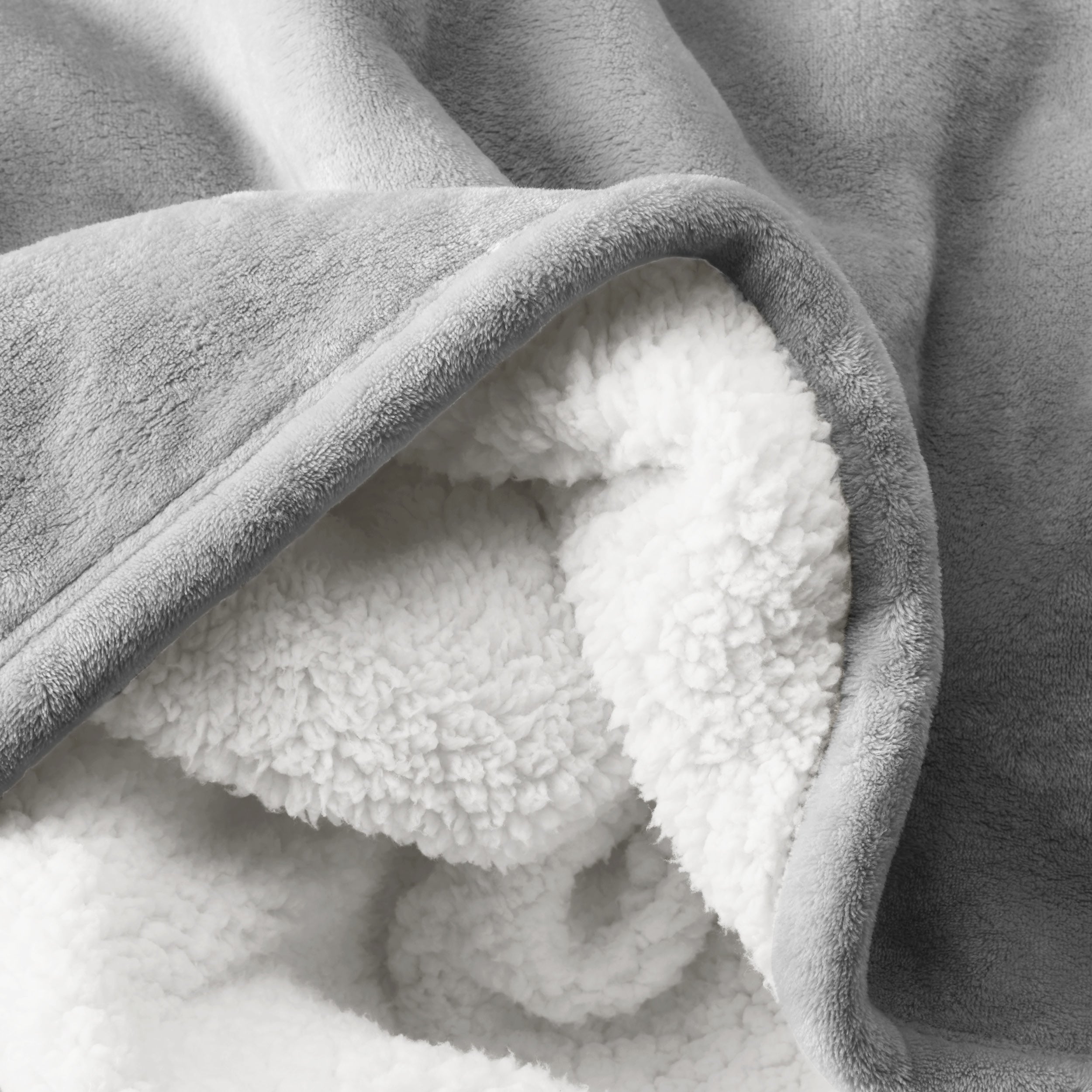 Close up of sherpa blanket showing texture of velvety soft side and sherpa backing