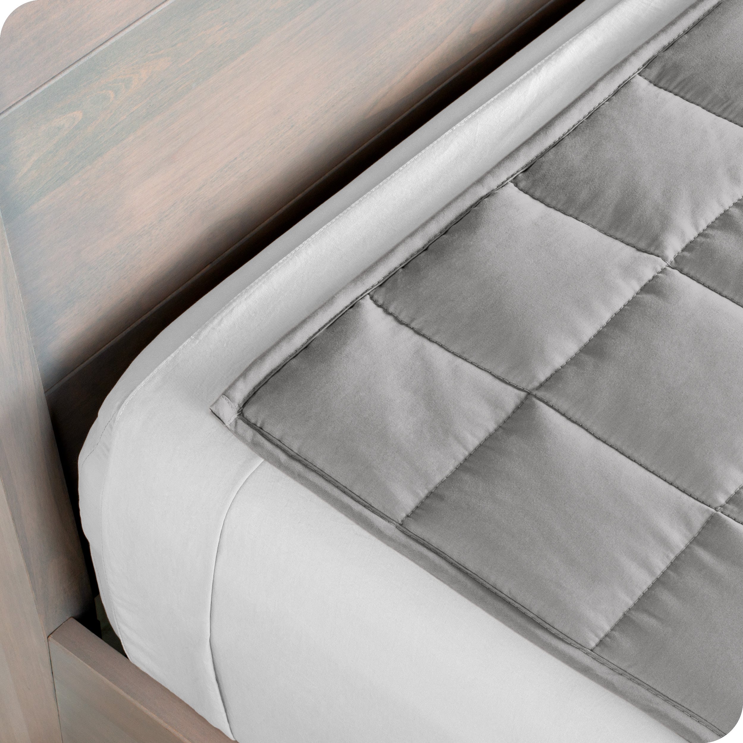Close up of the corner of a weighted blanket on a bed