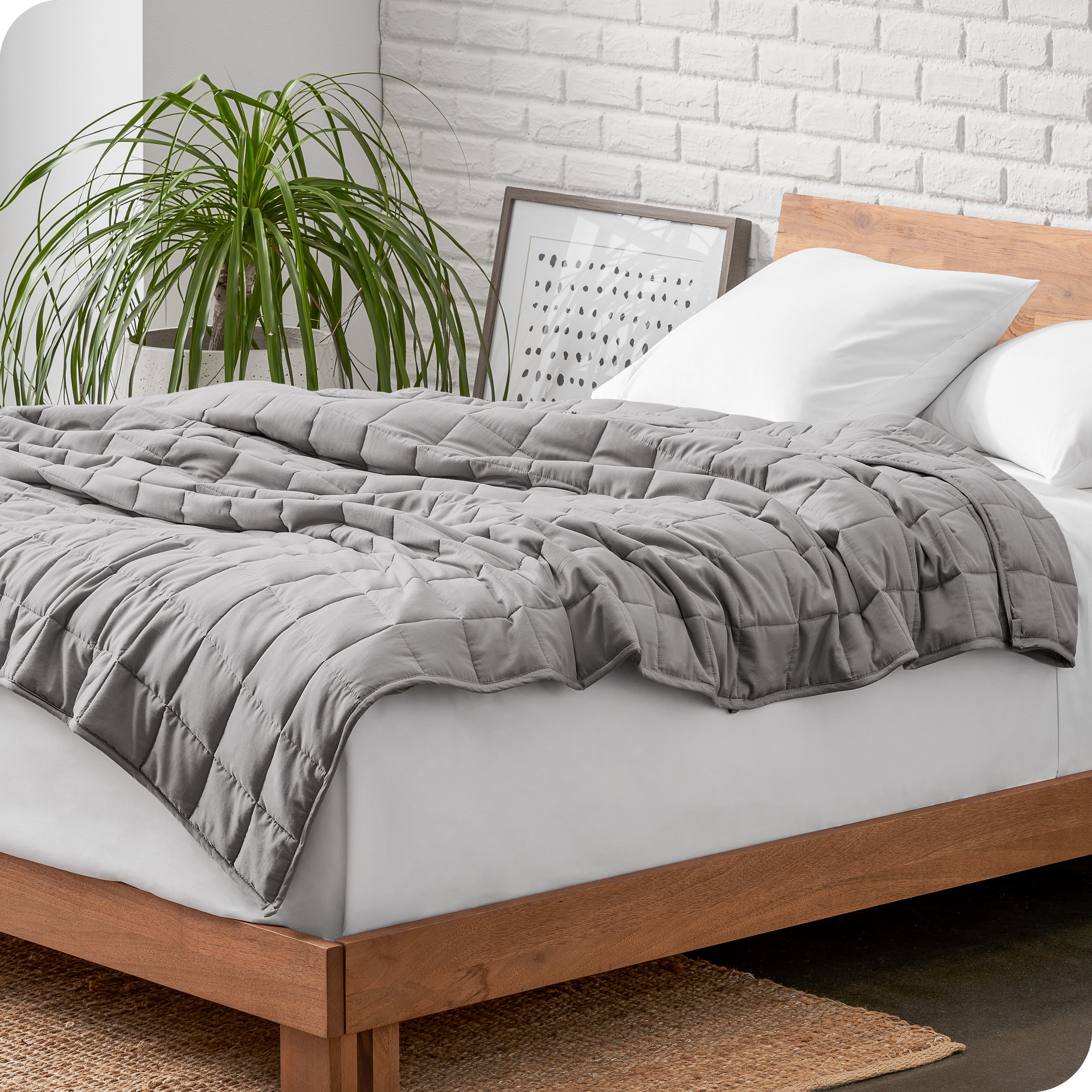 A cotton weighted blanket is loosely draped over a bed