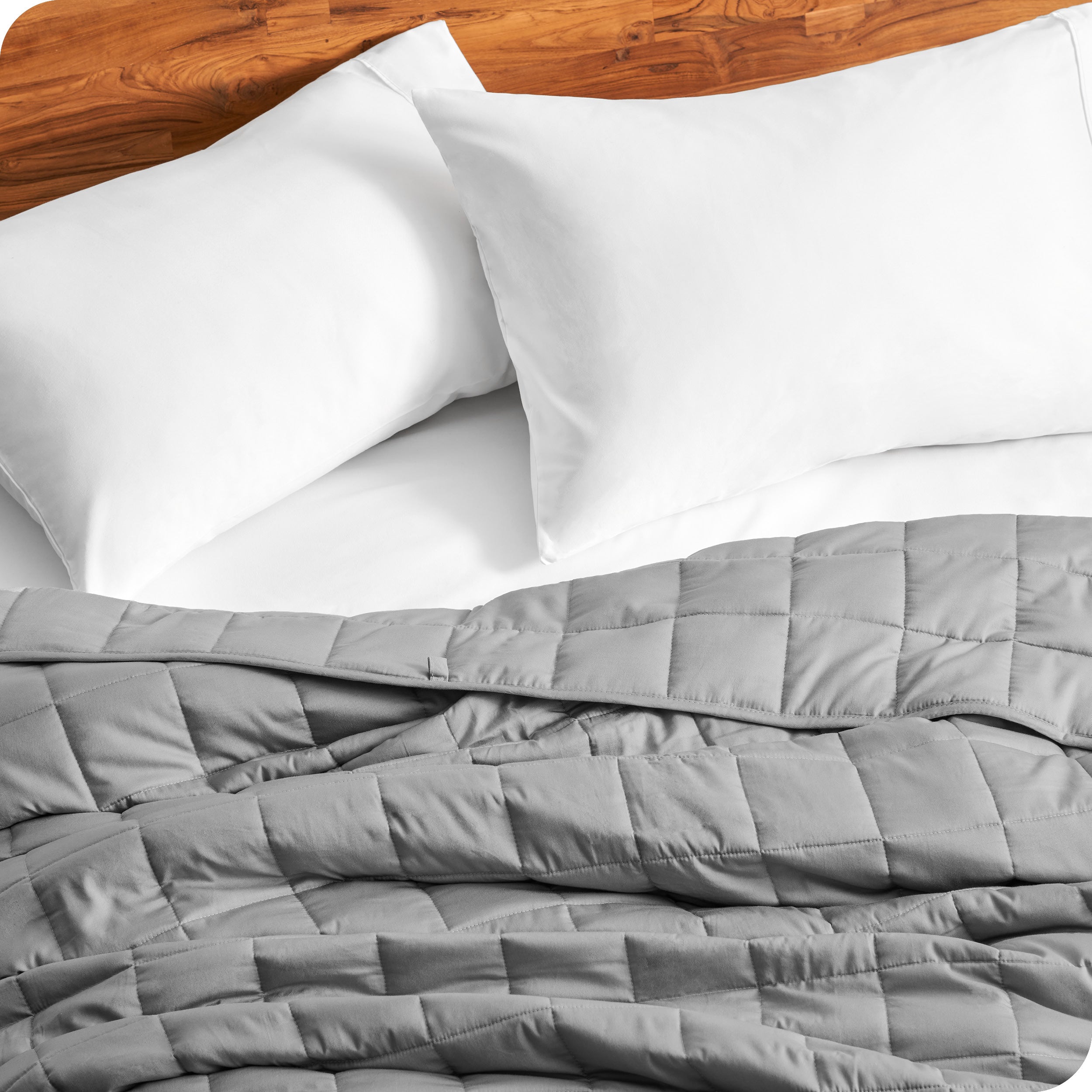 Close up of a weighted blanket on a bed with  2 pillows