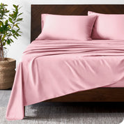 Wooden bed frame with bamboo sheets on the bed