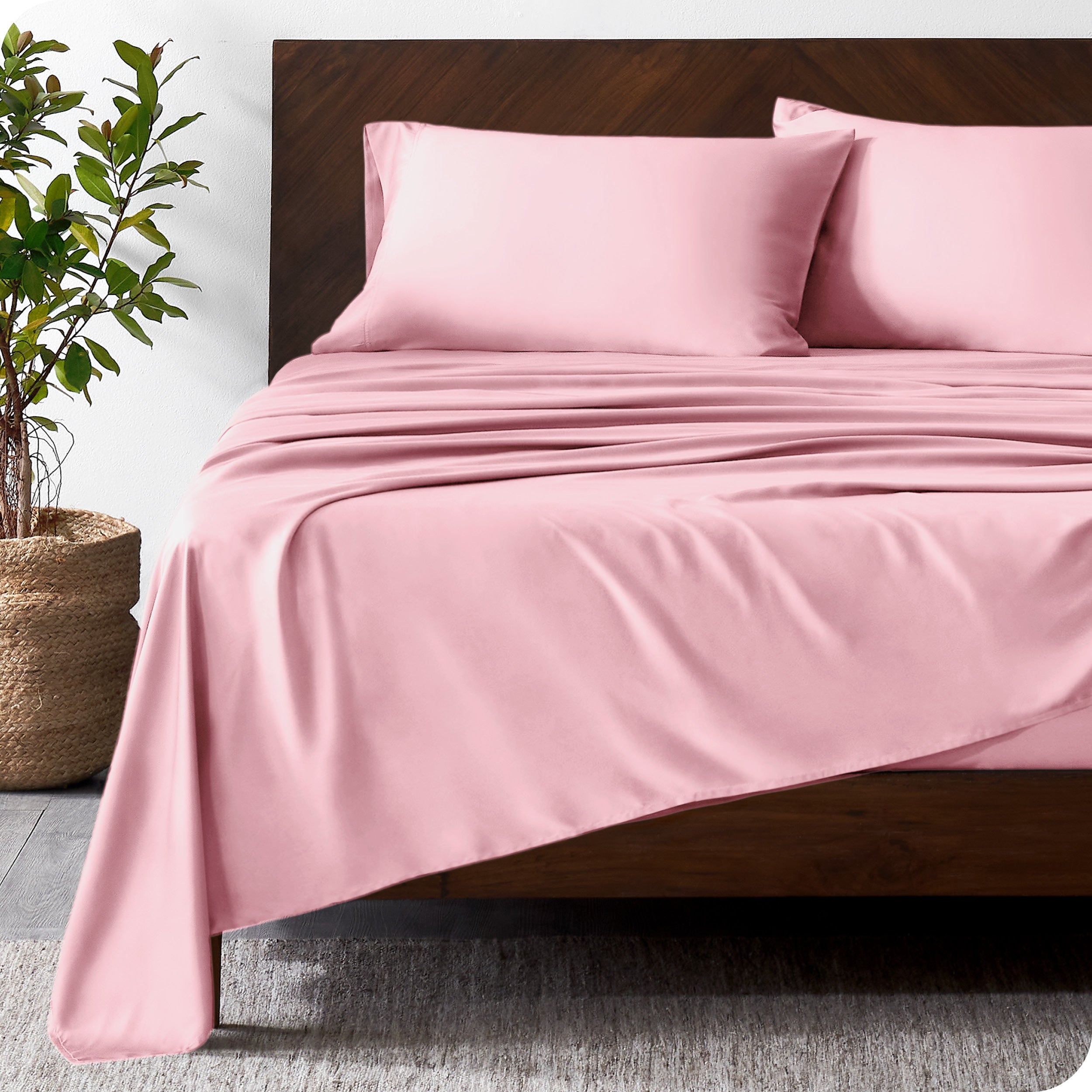 Wooden bed frame with bamboo sheets on the bed