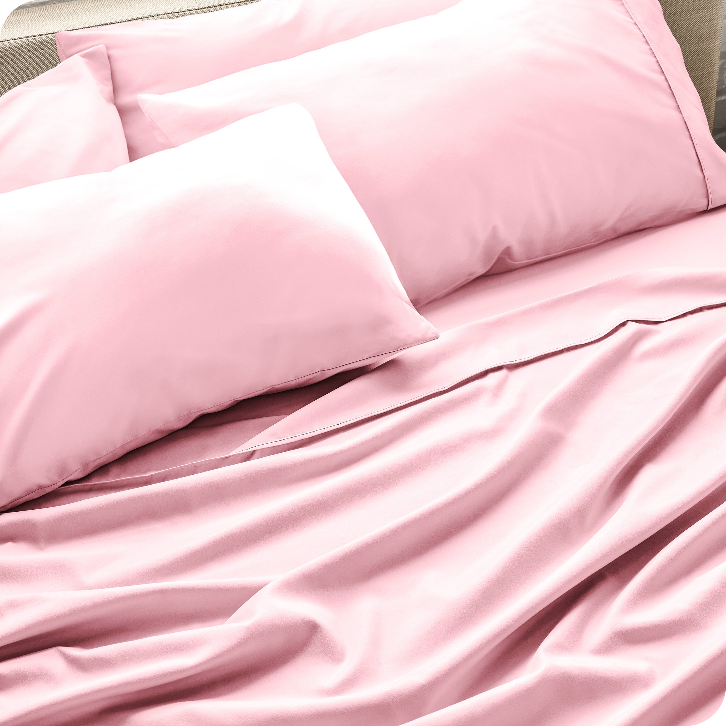 Close up of the microfiber bed sheets on a bed with four pillows.