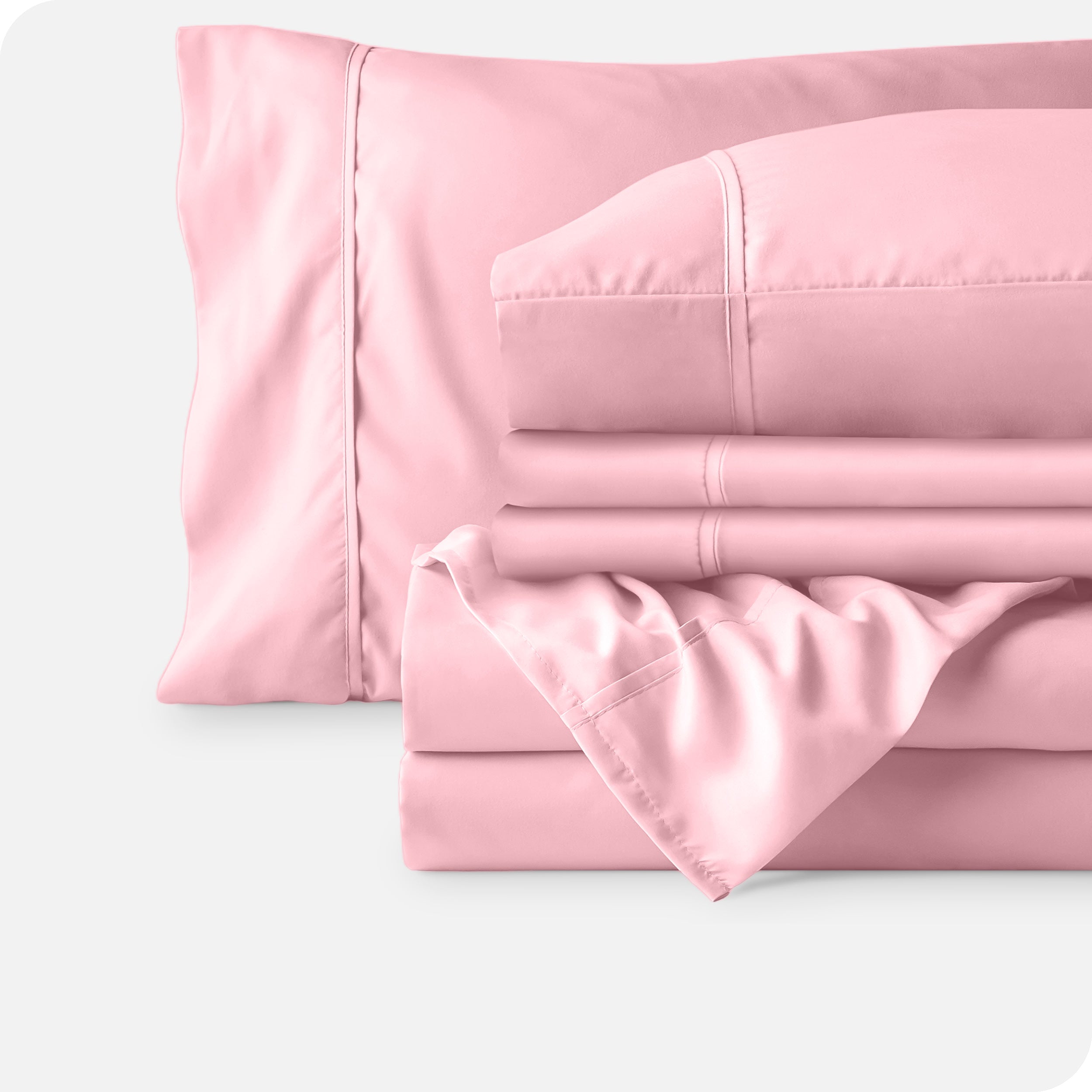 Microfiber sheets neatly folded with corner draped over, two folded pillowcases and two display pillows.