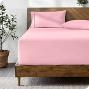 A modern bed with a fitted microfiber sheet made on the mattress. 