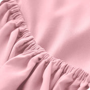 A modern bed with a fitted microfiber sheet on it