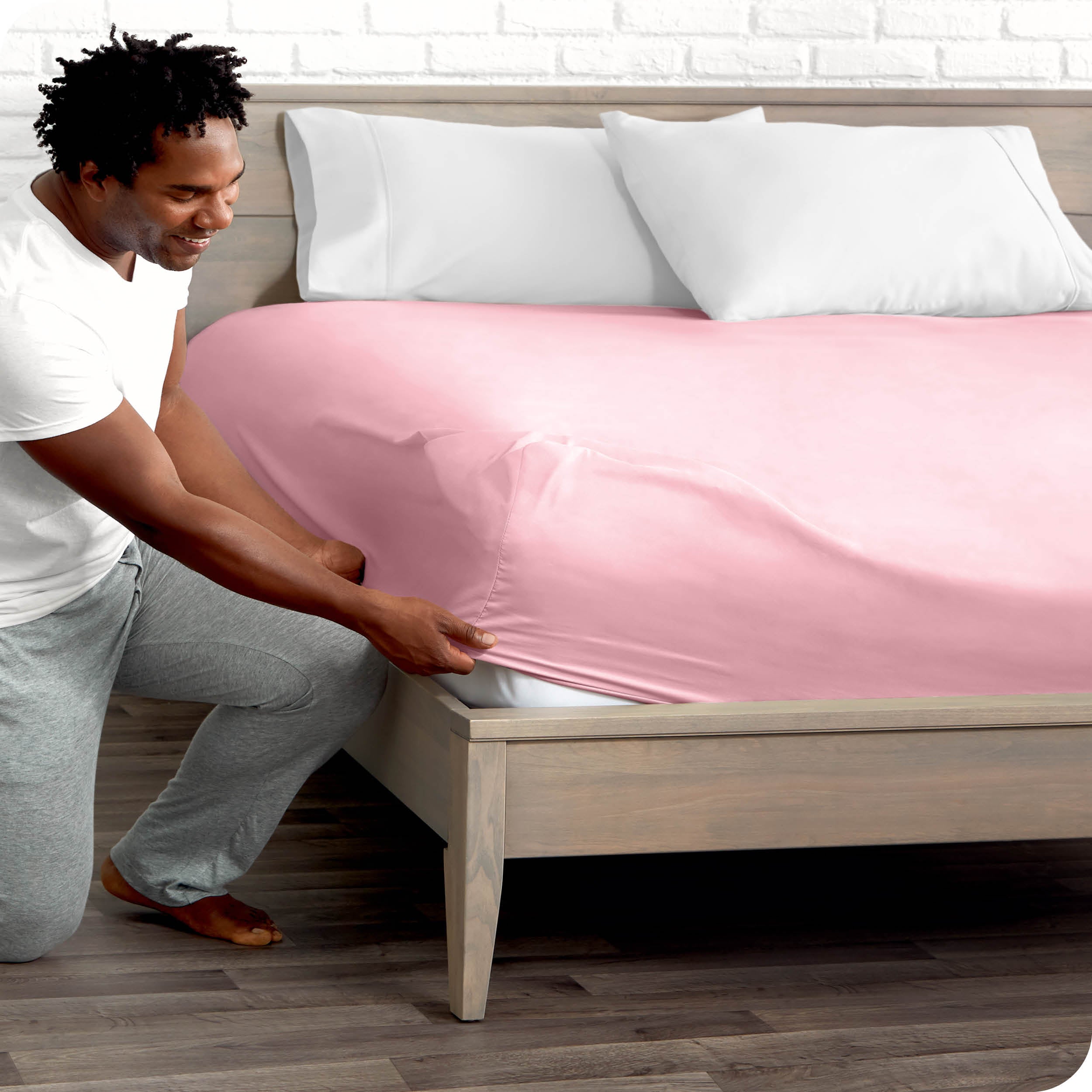 A man putting the microfiber fitted sheet on a mattress. 