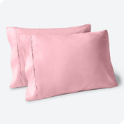 Two pillows on a white background with blue pillowcases on them