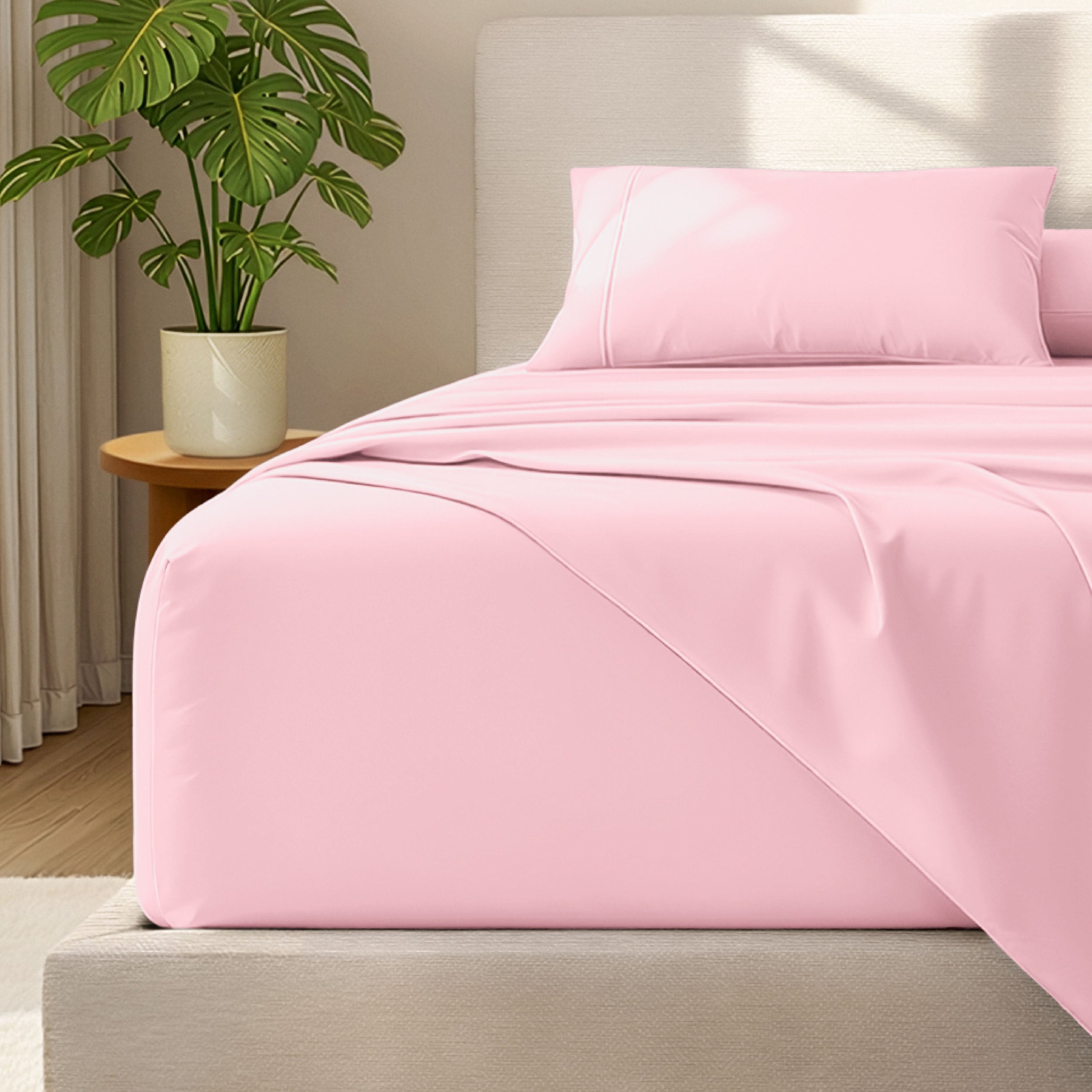 Microfiber bed sheets and pillowcases on a bed with a plant in the background