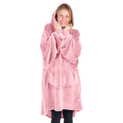 A woman is snuggled up in a hooded microplush wearable blanket