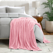 A textured microplush blanket is hanging over the corner of a bed